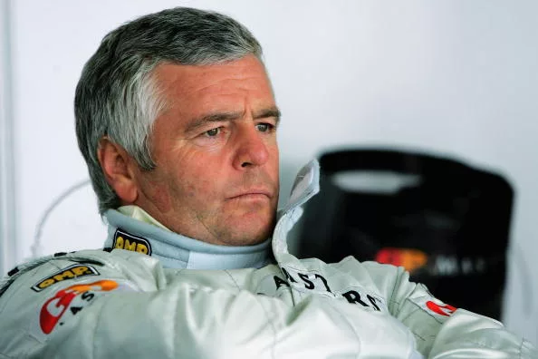 Derek Warwick in racing overalls, photographed in recent years